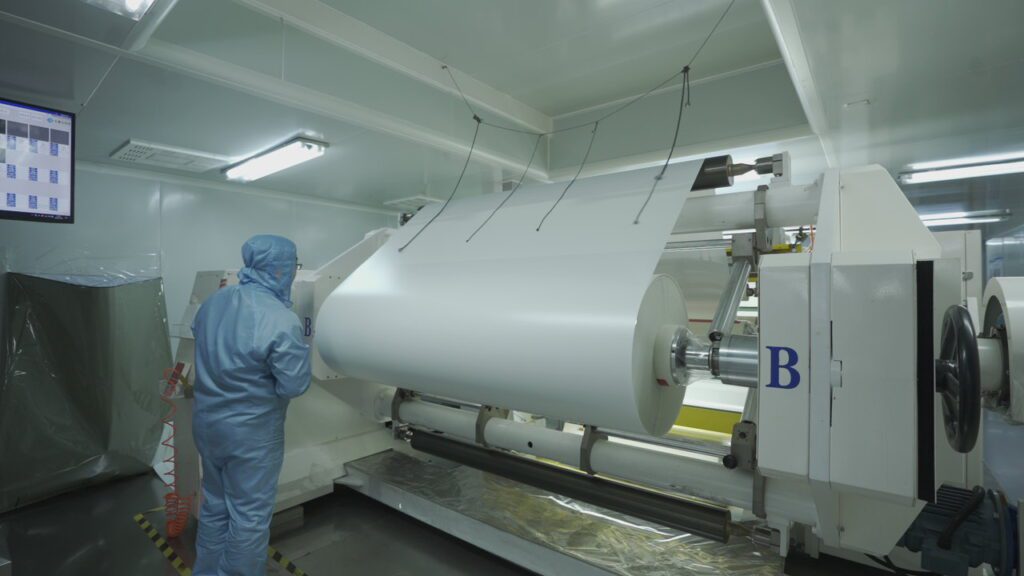 Workers handling big roll at tail section