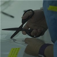 Gloved hands adjusting film sample on laboratory equipment