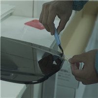 Lab technician testing film peel strength with instrument