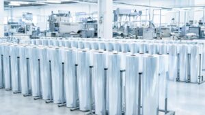 Clear PPF film rolls on a factory production floor representing direct manufacturer supply