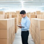 Planner counting stacks of PPF roll cartons in a warehouse for order quantity